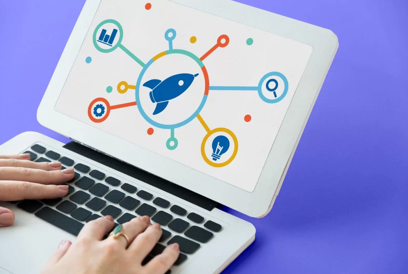 Laptop com uma tela exibindo um ícone de foguete conectado a diversos elementos digitais, simbolizando o crescimento acelerado. A imagem representa a expansão das marcas por meio de estratégias eficazes dentro do conceito de o que é marketing digital.