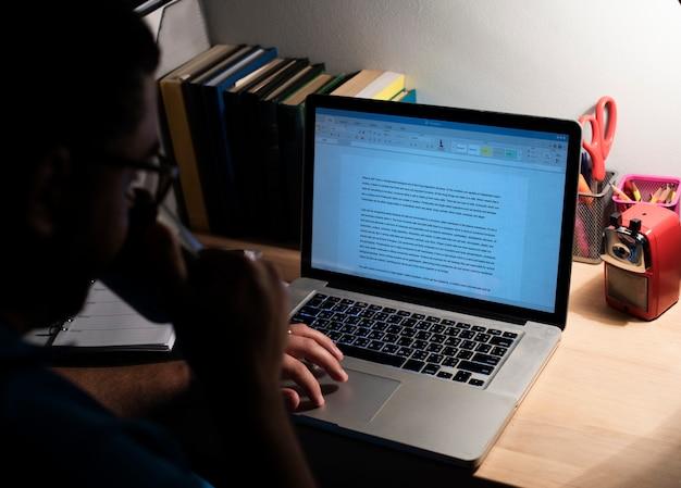 Homem trabalhando em um ambiente aconchegante, escrevendo um texto em seu laptop. A cena reflete o processo de criação de um copy persuasivo, essencial para engajamento e envolvimento.