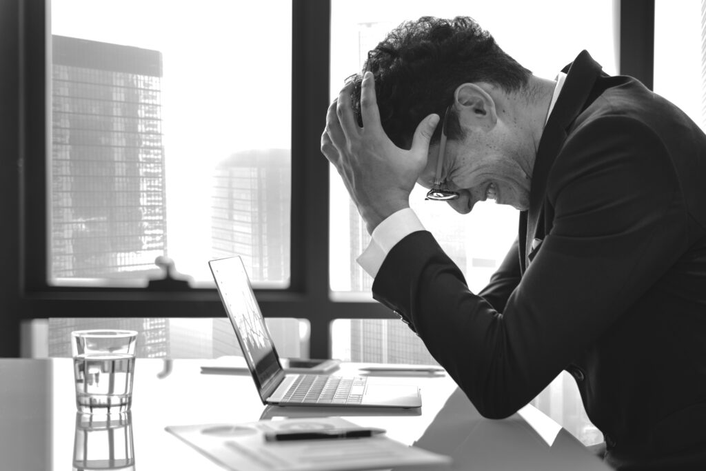 Profissional frustrado diante do computador, refletindo sobre os desafios do copywriting e a busca constante por criar textos persuasivos e eficazes no ambiente corporativo.