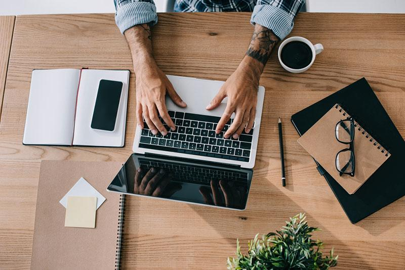 Ambiente de trabalho voltado para criação de estratégias de Marketing Digital com notebook e anotações.