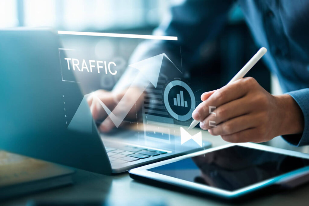 Homem analisando estratégias de Tráfego Pago simultaneamente no celular e no notebook em ambiente aconchegante.