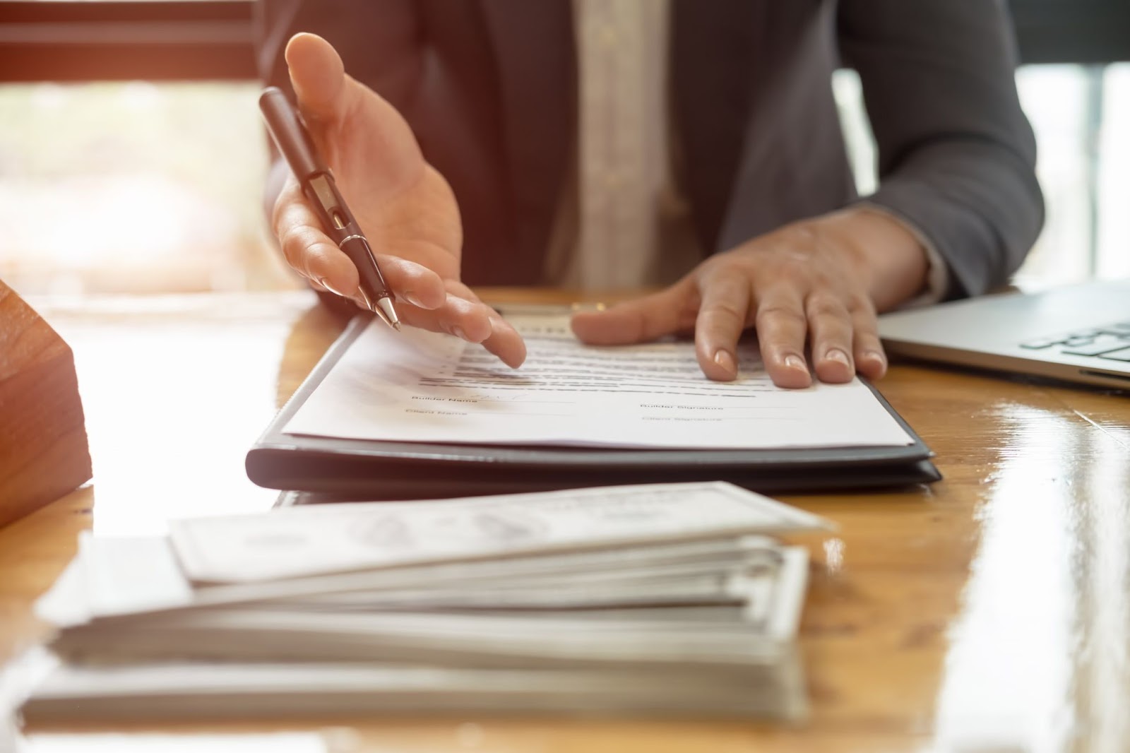 Cena de negociação ou acordo, com documentos e dinheiro, destacando a importância da formalização de negócios e estratégias que podem incluir o crescimento através de vendas online.