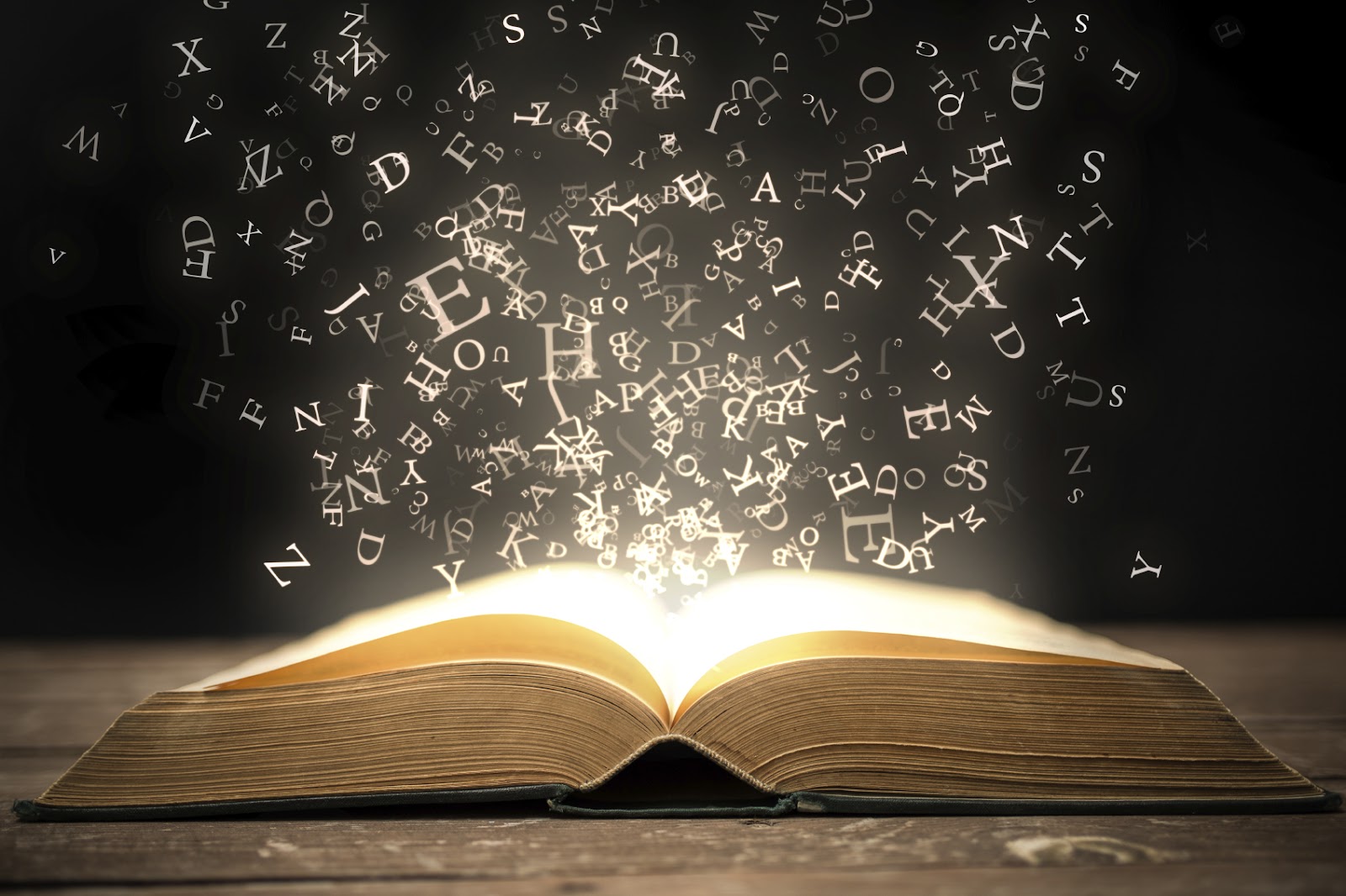 Um livro antigo e aberto em uma mesa de madeira escura. Letras e símbolos alfabéticos, iluminados por um brilho mágico, emanam das páginas, simbolizando o poder e a criatividade do copywriting.