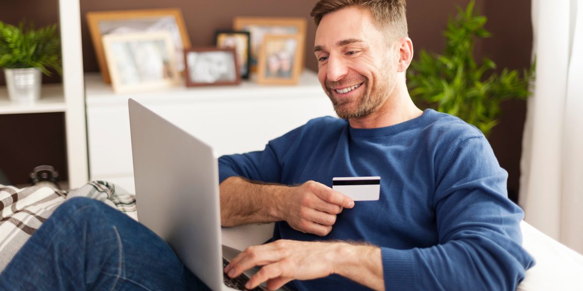 smiling-man-during-online-shopping-home